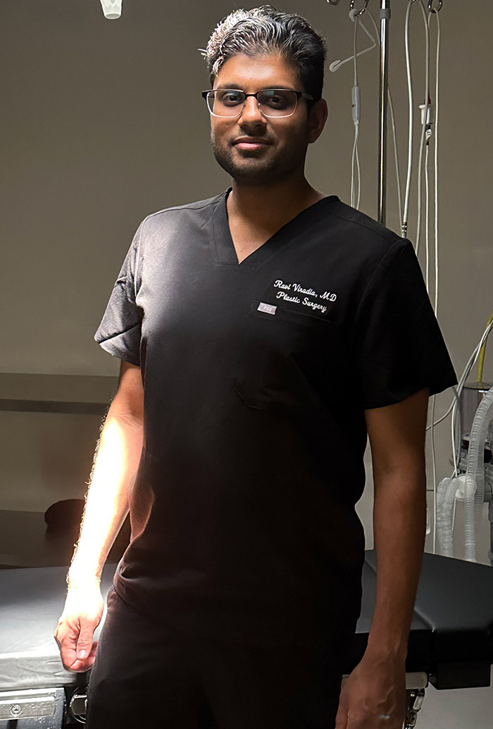 Dr. Viradia in scrubs stands in OR at Viradia Plastic Surgery in Tampa, Florida